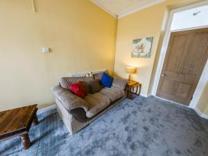 a living room with a couch and a table at NEWTON HEATH APARTMENT -750mtrs to beach - Spacious ground floor - Sleeps 6 in Porthcawl