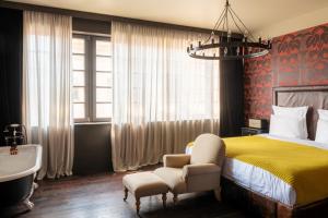 a bedroom with a bed and a tub and a sink at Rooms Hotel Tbilisi in Tbilisi City