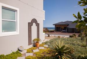 ein Haus mit einem Fenster und einem Garten in der Unterkunft 21 ON BAKOOND in Yzerfontein