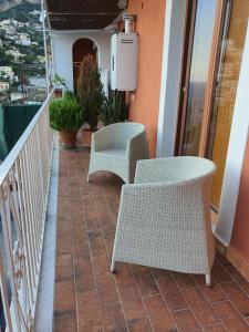 a balcony with two wicker chairs and a heater at La Casa di Nunzia B&B in Positano