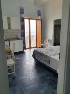 ein Schlafzimmer mit einem Bett und eine Küche mit einem Balkon in der Unterkunft La Casa di Nunzia B&B in Positano