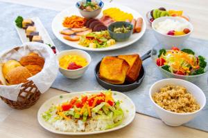 a table with plates of food and bowls of food at Rembrandt Style Naha in Naha