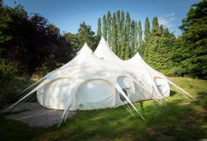 two tents sitting in the grass in a field at 8-Bed Lotus Belle Mahal Tent in The Wye Valley in Ross on Wye