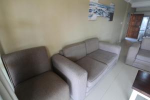 sala de estar con 2 sillas y sofá en Saints View Resort Unit 3, en Uvongo Beach