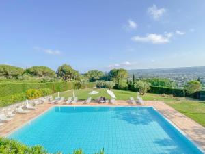 a swimming pool with chairs and a view of the city at Villa Saint Maxime in Saint Paul de Vence