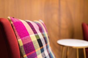 a plaid blanket on the back of a red couch at Hotel Vie Via - Just a room in Leeuwarden