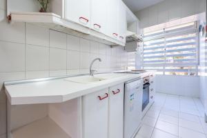 eine weiße Küche mit Spüle und Geschirrspüler in der Unterkunft Eurosol Carihuela in Torremolinos