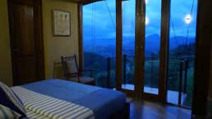 ein Schlafzimmer mit Bett und Balkon mit Aussicht in der Unterkunft Kandy Hindagala Retreat - Boutique Villa in Kandy Hills Sri Lanka in Kamburadeniya