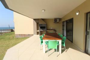 a kitchen and dining room with a table and chairs at Saints View Resort Unit 4 in Uvongo Beach