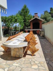 a picnic table and bench on a stone patio at Apartments Sollis in Trogir