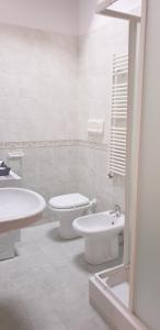 een badkamer met 2 wastafels, een toilet en een bad bij APPARTAMENTO TORRE in Cormano