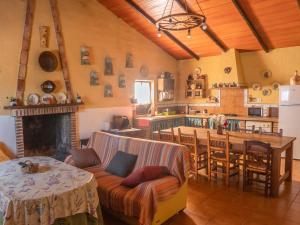 a kitchen and living room with a couch and a table at Casa Rural Huerta la Lapa in Cañete la Real