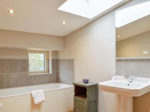 a bathroom with a sink and a tub and a mirror at Ash Hill - Uk36199 in Fordingbridge