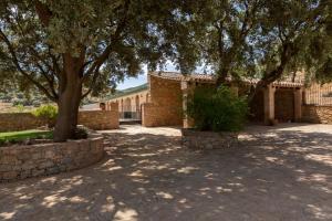 une cour avec des arbres et un bâtiment en briques dans l'établissement El recreo de Martalia, à Ronda
