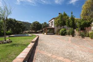 une maison avec un jardin et une allée dans l'établissement El recreo de Martalia, à Ronda