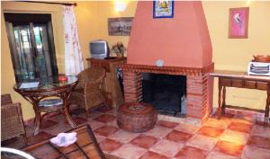 sala de estar con chimenea de ladrillo y mesa en Cortijo Zalamea en Zalamea la Real