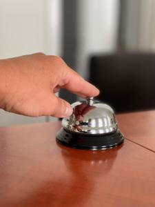 een hand drukt een bel op een bureau bij WINDSOR SPA Hotel in Karlsbad