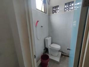 a small bathroom with a toilet and a shower at Charisma Residence Syariah in Surabaya +37 photos