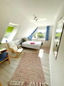 a attic room with a bed and a rug at Ferienwohnung Fröhlich in Husum