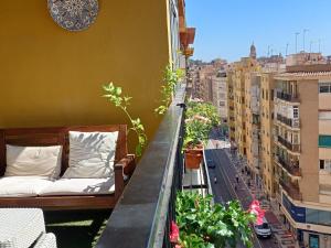 a balcony with beds and plants on a building at Sun And Chic Malaga in Málaga