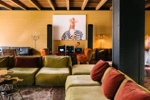 a living room with couches and a zebra picture at Rooms Hotel Tbilisi in Tbilisi City