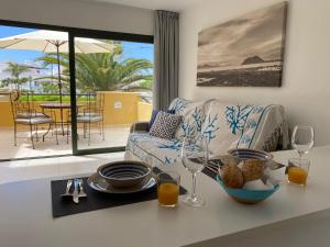 a living room with a couch and a table with wine glasses at Casa del Caballero in Corralejo