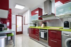 une cuisine avec des placards rouges et des comptoirs verts dans l'établissement Apartamento Levante en Chinchilla con vistas, à Chinchilla de Monte-Aragón