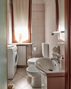 uma casa de banho branca com um WC e um lavatório em Terrazza di Alfieri em Asti