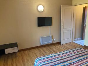 a bedroom with a bed and a tv on the wall at Locations saisonnières The VOLCANO in Le Tampon