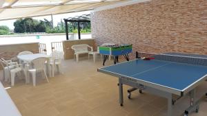 Habitación con mesa de ping pong y sillas. en Villa Silvia Luxury Residence, en Taviano