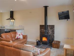a living room with a couch and a fireplace at Quails Nest in Edlingham