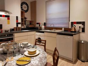 uma cozinha com uma mesa com uma toalha de mesa em Buckieburn em Banknock