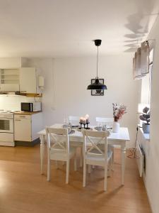a kitchen with a white table and chairs in a room at Frost Longstay Sundellsgatan 3 H in Haparanda