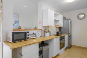 a kitchen with white cabinets and a microwave at San Lameer Villa 2536 - 3 Bedroom Superior - 6 pax - San Lameer Rental Agency in Southbroom
