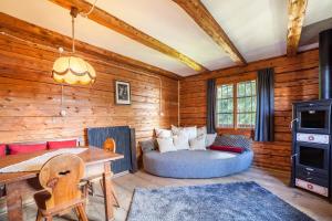 a living room with a bed and a wooden wall at Bergchalet Schennaberg in Schenna