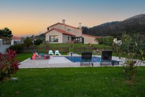 a house with a backyard with a pool and chairs at Luxury Singular Villa Carolina in Corrubedo