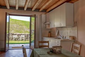 a kitchen with a table and a view of a yard at Agriturismo Il Pianetto in Verona