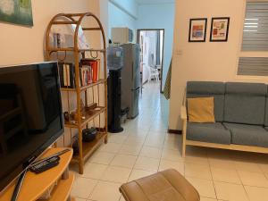 a living room with a couch and a television at Private Apartment Wakin Residence, City Centre, Port Louis in Port Louis