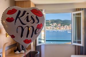 阿雅克肖的住宿－阿雅克肖阿米雷特貝斯特韋斯特酒店，一只心气球,在窗前写着吻我
