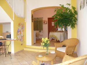 a living room with yellow walls and a table with flowers at B&B San Martino in Misterbianco