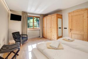 ein Schlafzimmer mit einem Bett, einem Stuhl und einem TV in der Unterkunft Chalet Sonne Superior2 4 in Livigno