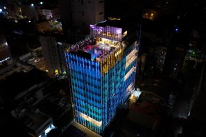 a tall building with lights on top of it at night at Pearl Grand By Rathna in Colombo