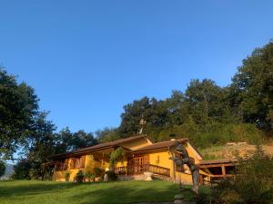 ein Haus auf einem Hügel mit Bäumen im Hintergrund in der Unterkunft La Peñona, Carancos48, Nava in Nava