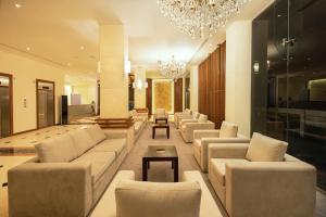 a living room with couches and a chandelier at Pearl Grand By Rathna in Colombo
