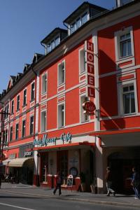 un edificio rojo con un cartel para un club de cazadores de alimentos en Altstadthotel Mosser, en Villach