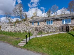 a stone house with a stone wall at Limecroft in Malham