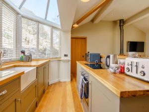 a large kitchen with wooden counters and a window at Limecroft in Malham