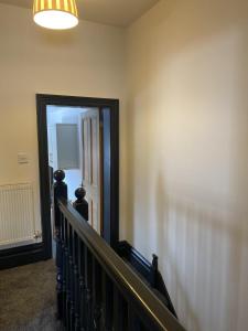 a hallway with a staircase with a mirror and a door at Wilson 74 in Darlington