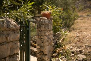 una recinzione con una pianta in vaso sopra di essa di Apartman Silna your new home with terrace and garden a Bobovišća