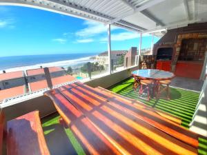 a bench on a balcony with a table and the beach at Beach Splendor @ 24 La Crete Sands in Margate